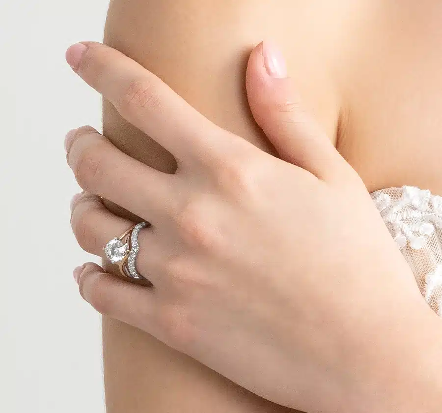A female hand wearing a diamond ring and wedding band